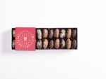 Luxury assortment of stuffed dates with ashta, hazelnut, nut praline, and mastique fillings, coated in milk and dark chocolate.