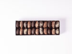 Luxury assortment of stuffed dates with ashta, hazelnut, nut praline, and mastique fillings, coated in milk and dark chocolate.